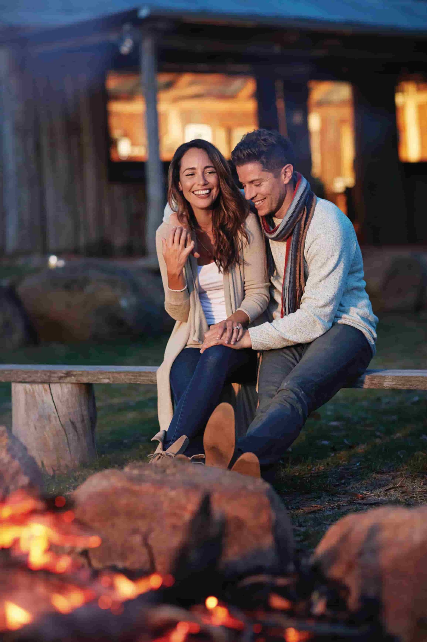 A couple sitting by a fire in Granite Belt Wine Country