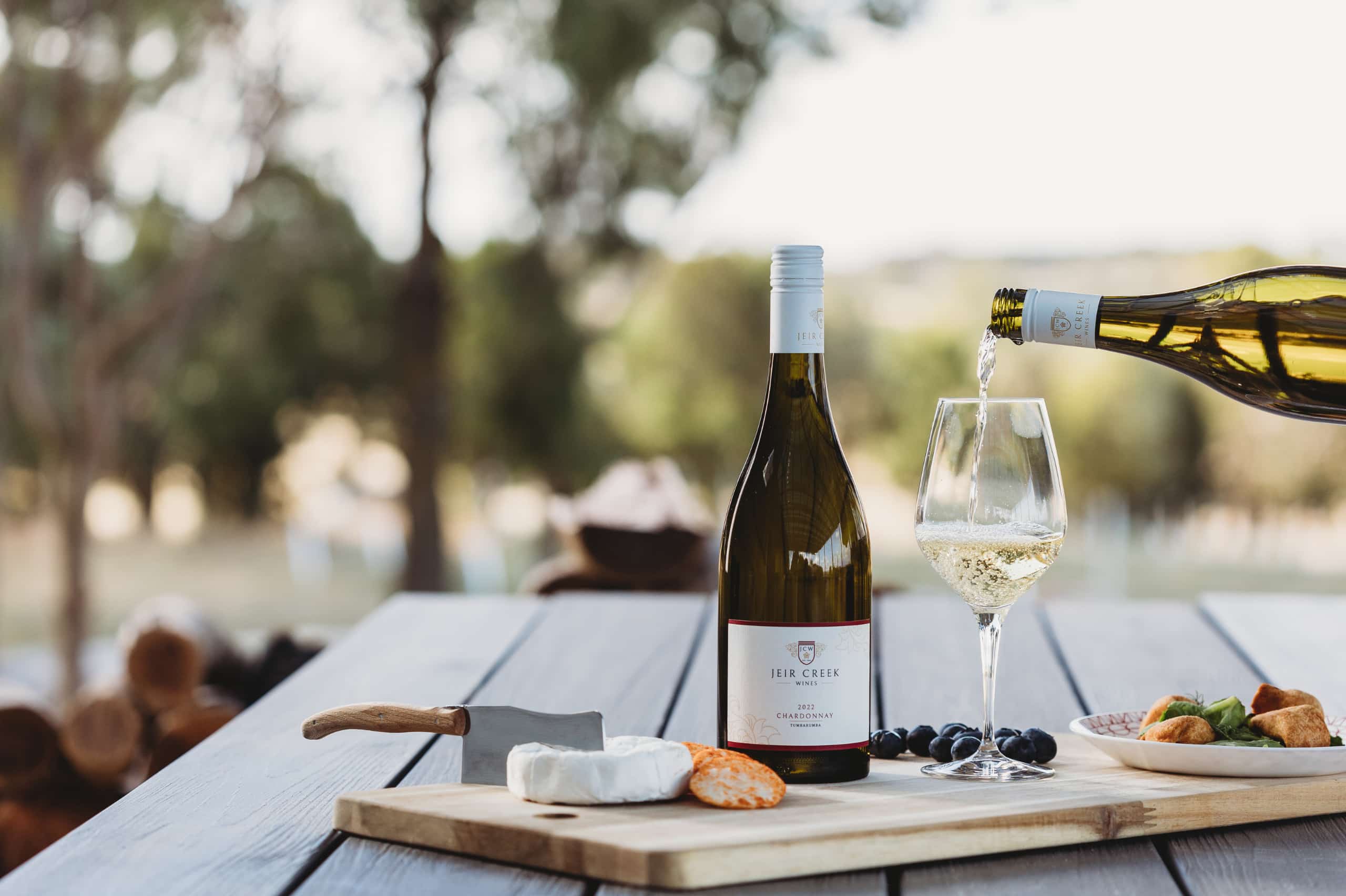 A bottle of Jeir Creek Wine Chardonnay next to a cheese board