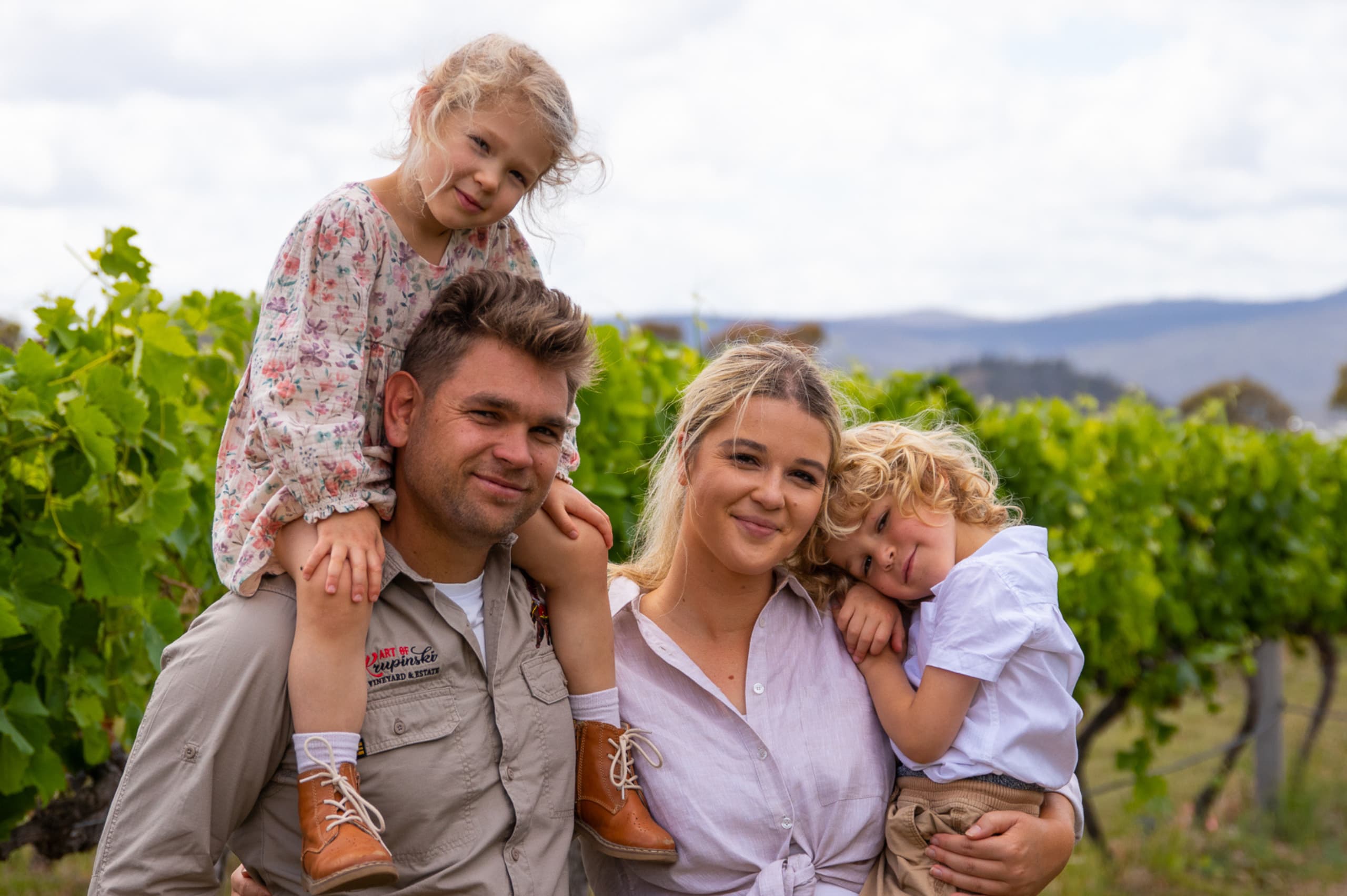 Artur and Natalia Krupinski and their two children standing in their vineyard
