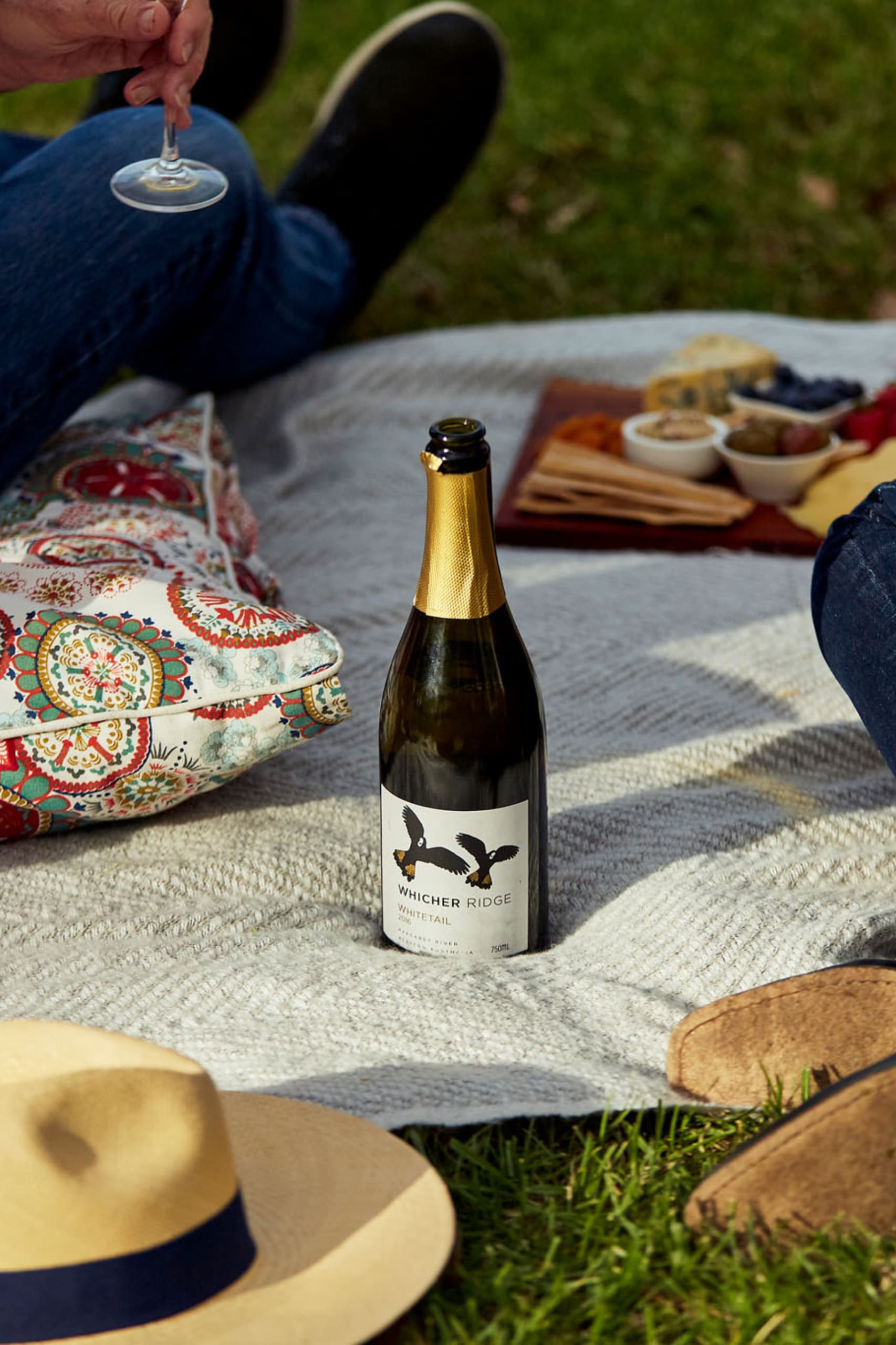 A bottle of Whicher Ridge wine resting on a picnic rug